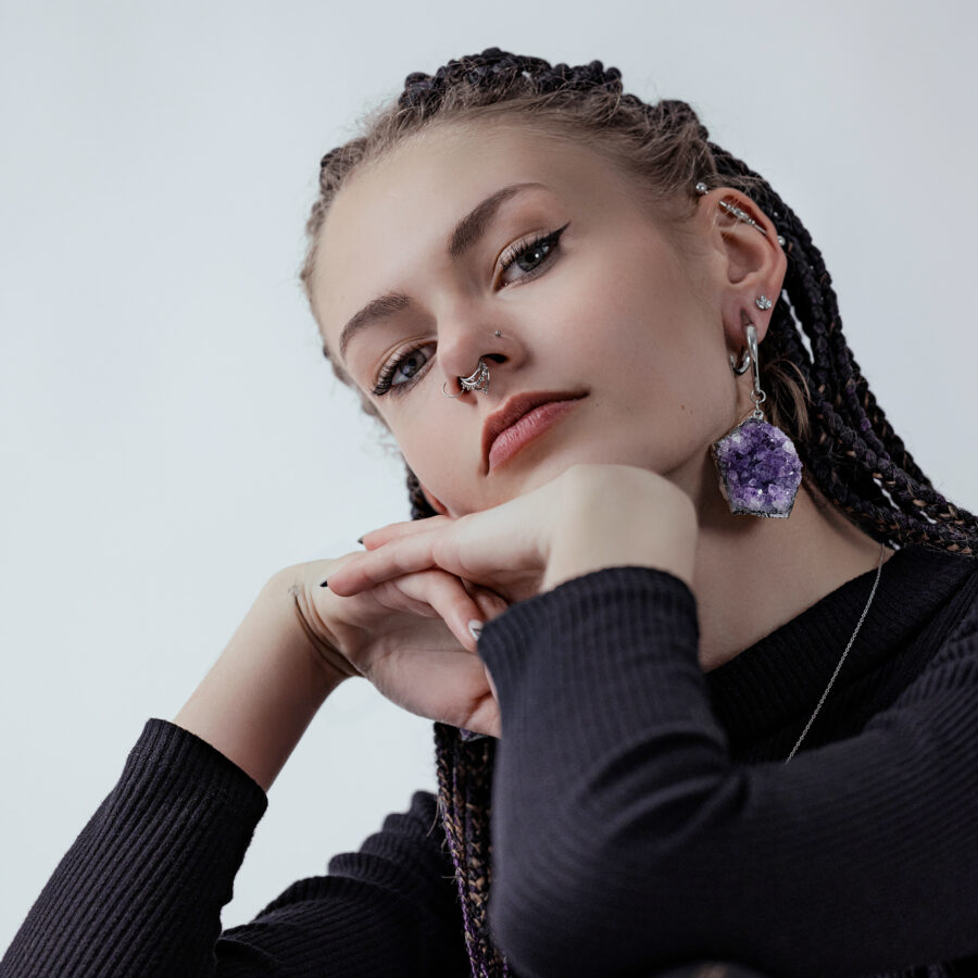 Mujer con pesa para oreja de amatista de acero quirúrgico plateado y piercings
