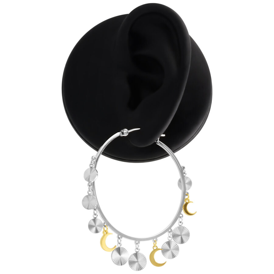 Pendientes colgantes de plata y oro en un expositor negro