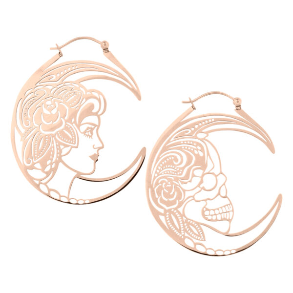 Dos pendientes de oro rosa con diseño de calavera y figura femenina sobre fondo blanco