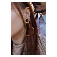 Herz Creolen Roségold im Ohr getragen Roségoldene Herz Creolen am Ohr einer Frau, im Hintergrund ein Mann