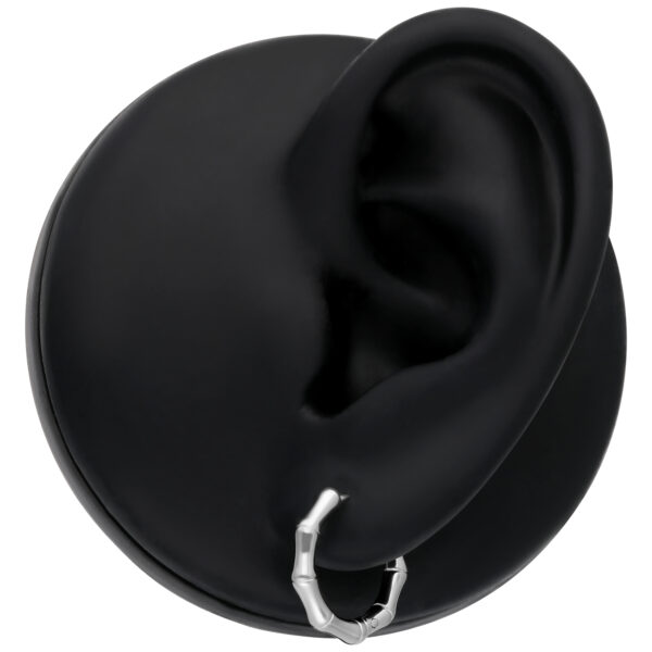 Pendientes de bambú plateados en modelo de oreja negra sobre fondo neutro