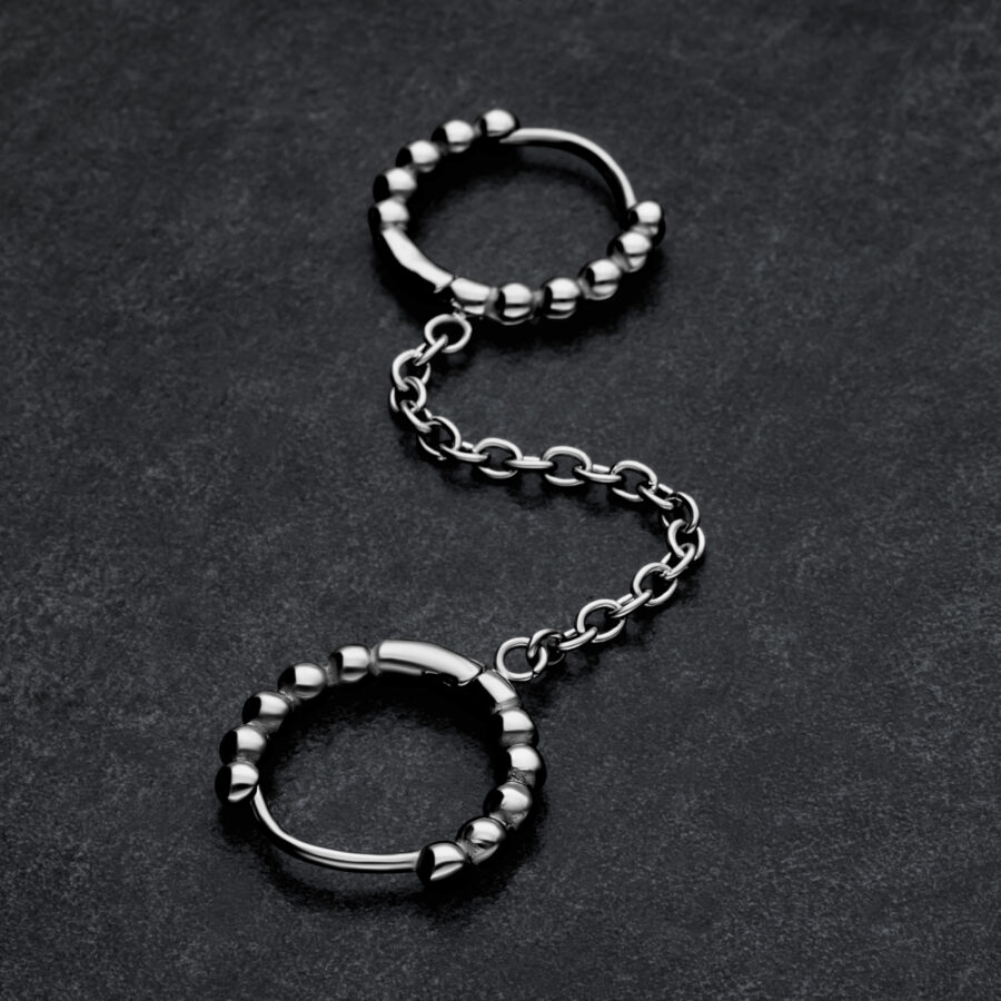 Aros de Doble Huggie con Bolas Plateadas y conexión de cadena sobre fondo oscuro