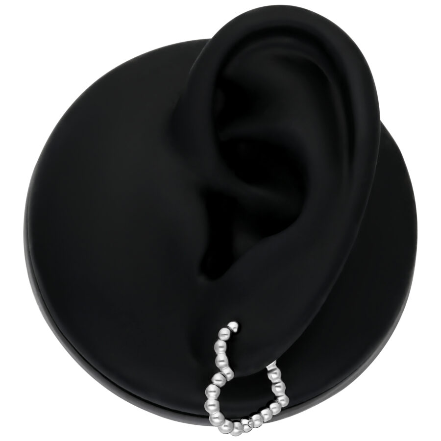 Aro Bubble de Corazón plateado en modelo de oreja negra sobre fondo blanco