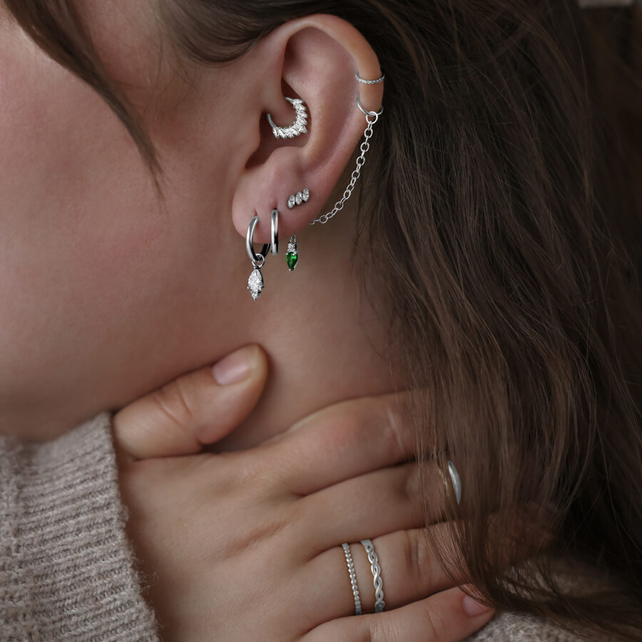 Mujer lleva pendientes Little Tear Hoops de acero quirúrgico en varios colores y tamaños.
