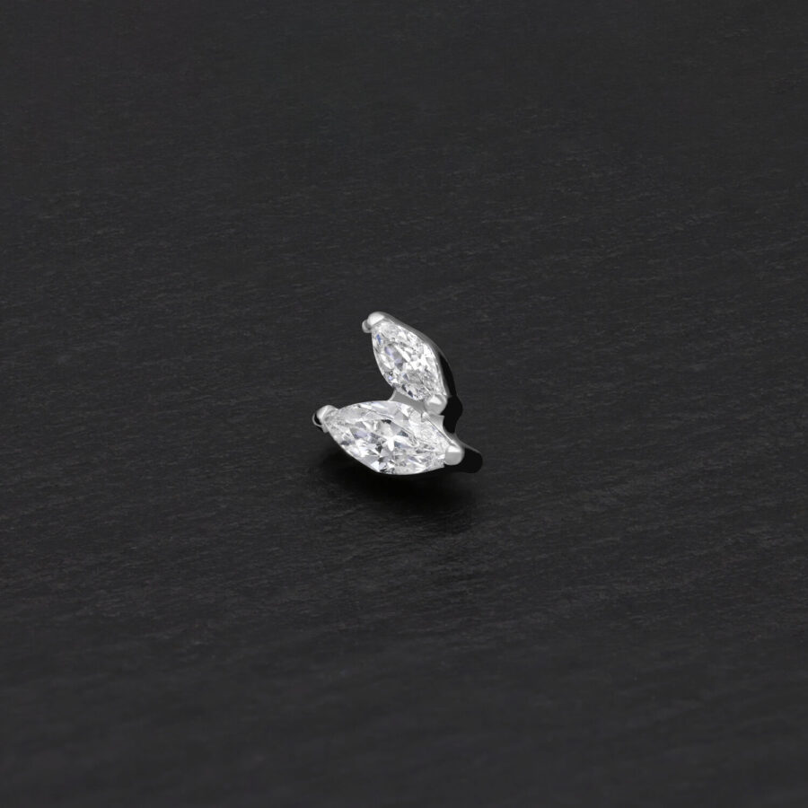 Adorno doble marquise plateado con piedras cristalinas sobre fondo negro