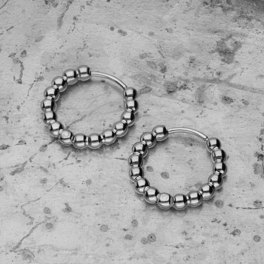 Dos aros Bubble de plata de acero inoxidable sobre fondo de hormigón gris