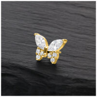 Aro de mariposa dorado con cristales claros sobre fondo negro