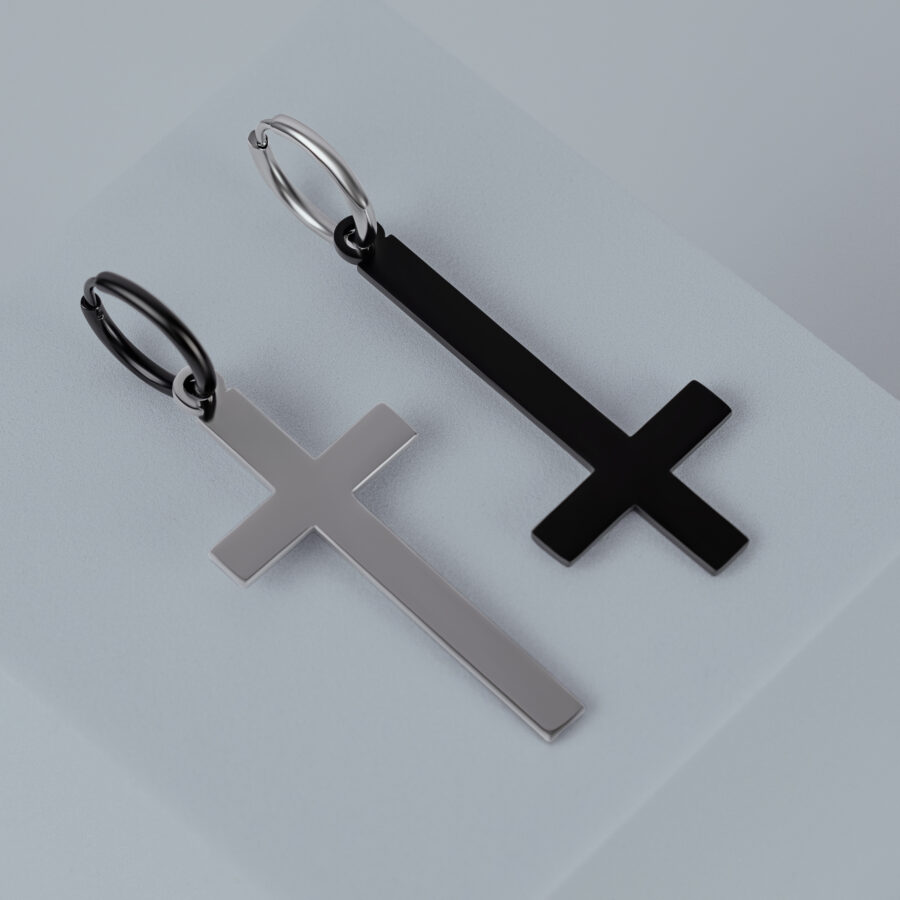 Dos pendientes cruz de acero quirúrgico en oro y negro sobre fondo gris