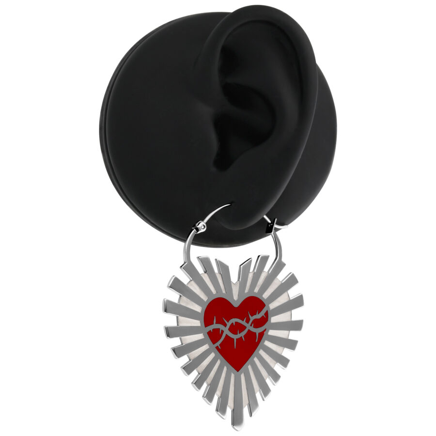 Pendientes plateados con corazón rojo y alambre de púas sobre fondo negro