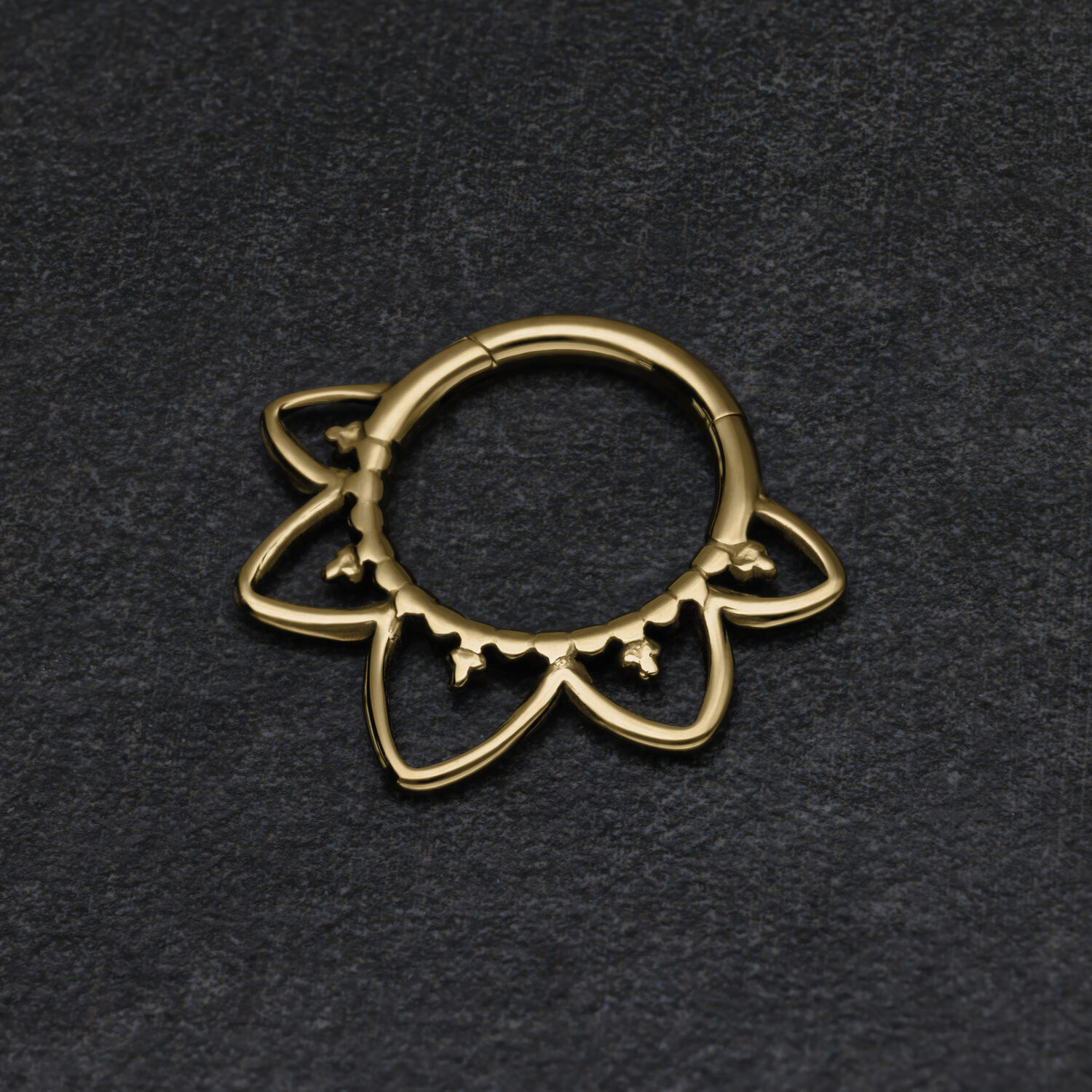 Clicker de Septum Oriental Dorado Clicker de septum dorado con diseño oriental sobre fondo oscuro