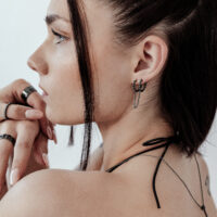 Pendientes Double Huggie Negros en la Oreja Mujer con pendientes Double Huggie negros y pelo corto