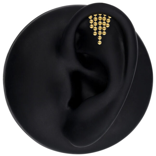 Aro Helix dorado para la oreja con cristales claros sobre fondo negro