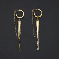 Pendientes dorados en forma de triángulo con colgante de cadena sobre fondo oscuro