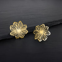 Pendientes de flores doradas de acero quirúrgico Dos pendientes de flores doradas sobre fondo oscuro
