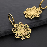 Aros Fine Flower dorados de acero quirúrgico Dos pendientes dorados en forma de flor sobre fondo negro