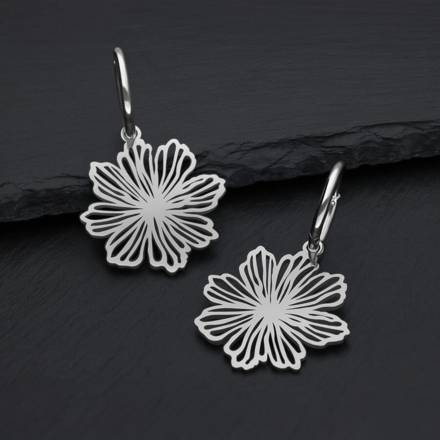 Pendientes de acero inoxidable plateados con diseño floral sobre fondo oscuro