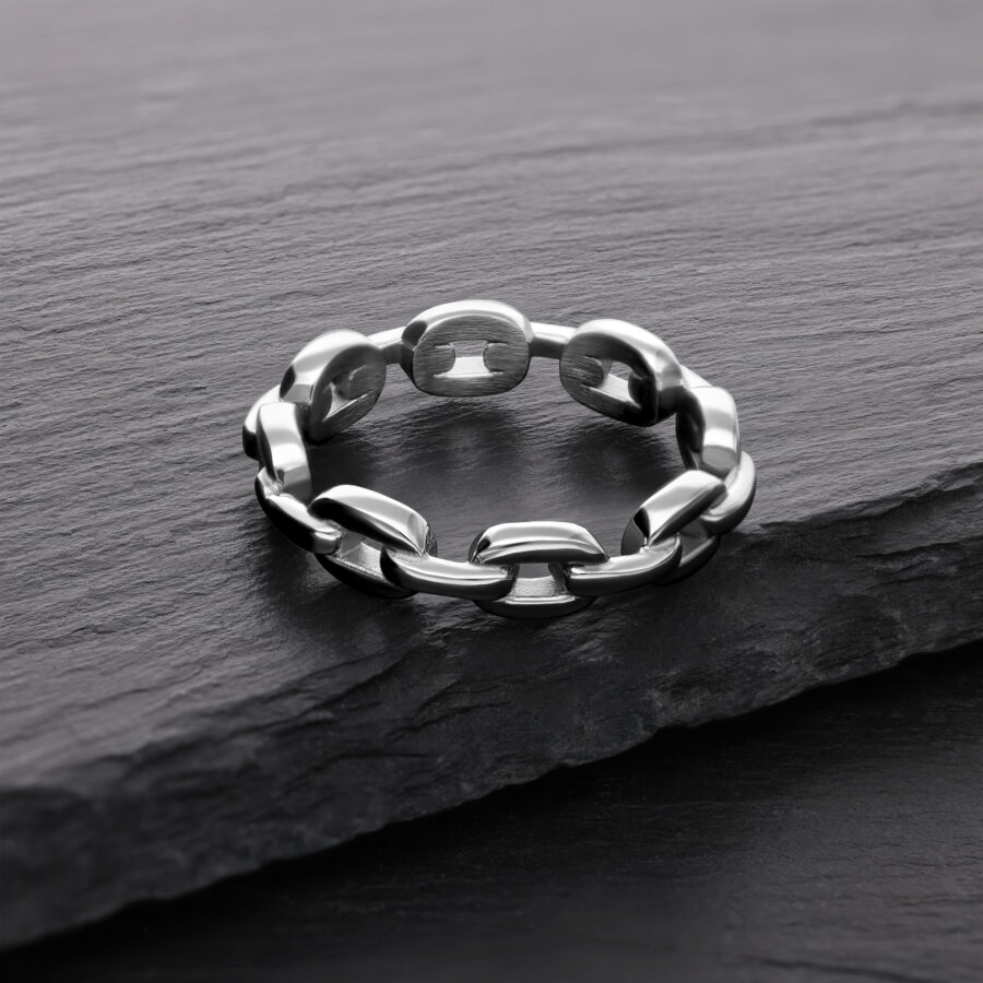 Anillo de cadena de eslabones plateado de acero quirúrgico sobre piedra oscura
