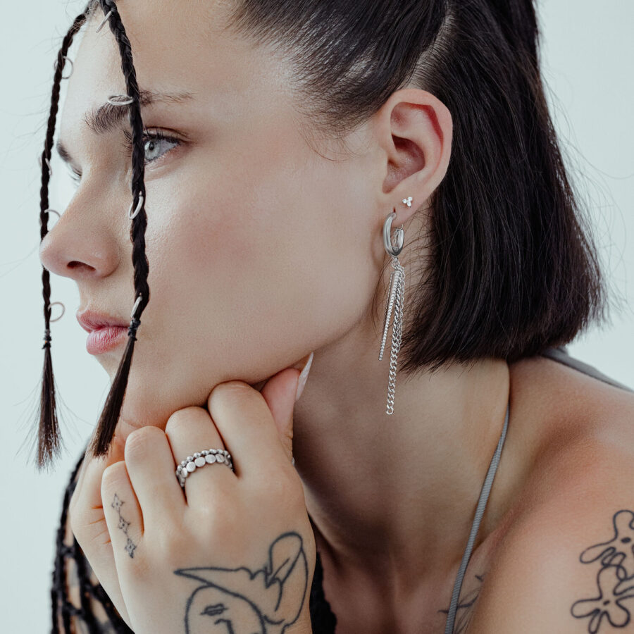 Mujer con cabello negro lleva pendientes Triangle plateados