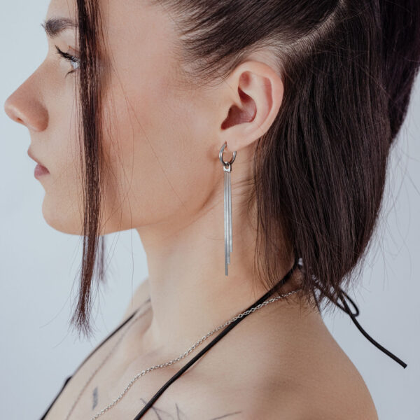 Mujer con aros de cadena de serpiente en plata, vista lateral