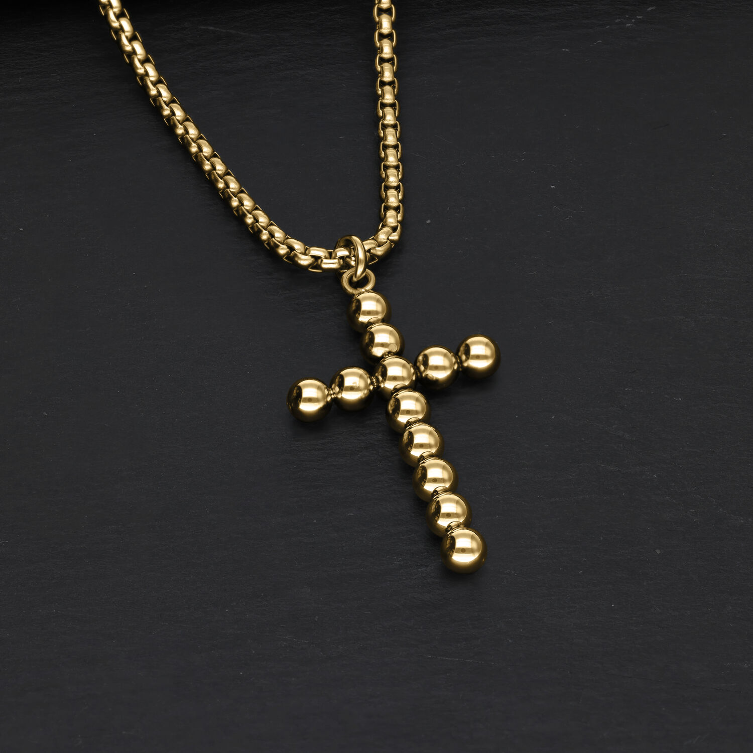 Collar de oro Bubble Cross de acero quirúrgico sobre fondo negro
