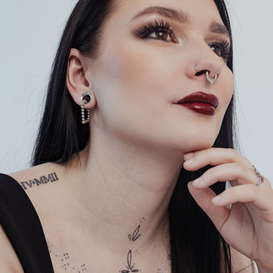 Mujer con aros Bubble Polygon en negro y plata, primer plano