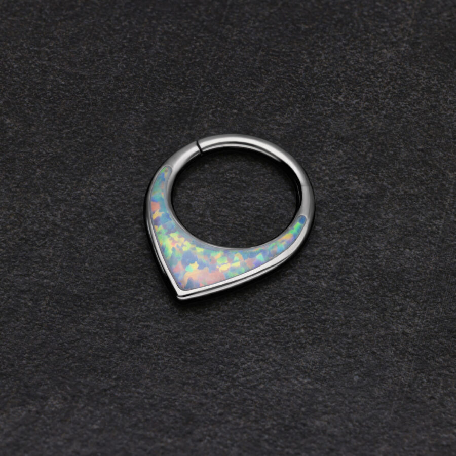 Septum clicker plateado con ópalo sintético sobre fondo negro