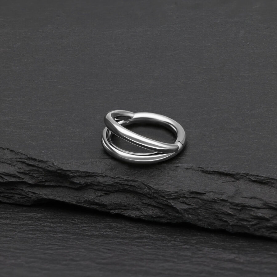 Anillo clicker de doble fila de plata de titanio sobre fondo negro