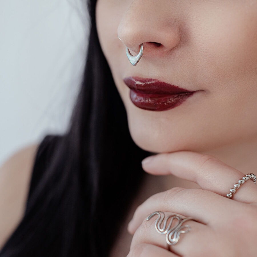 Mujer con septum clicker plateado y labios rojos