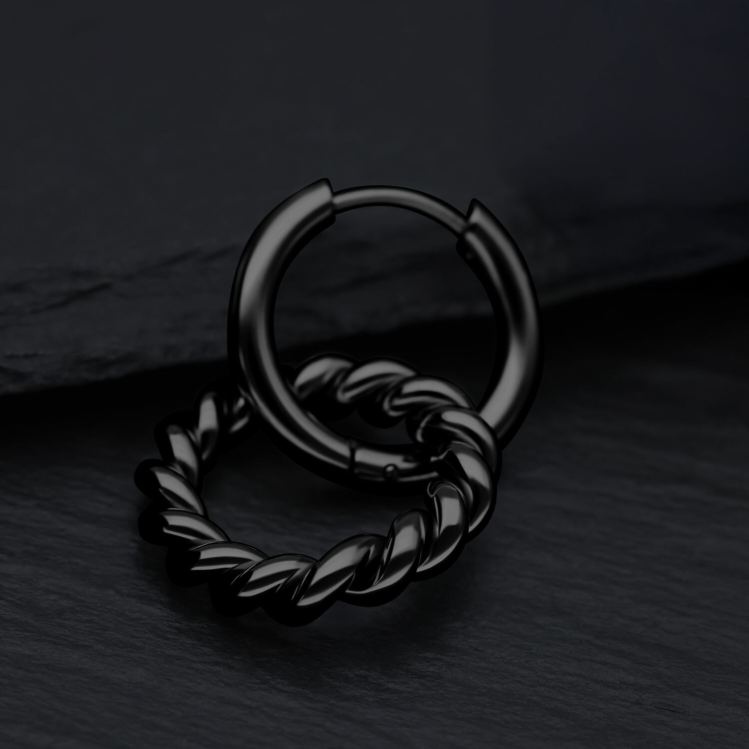 Aros negros, alto brillo con diseño torcido sobre fondo oscuro