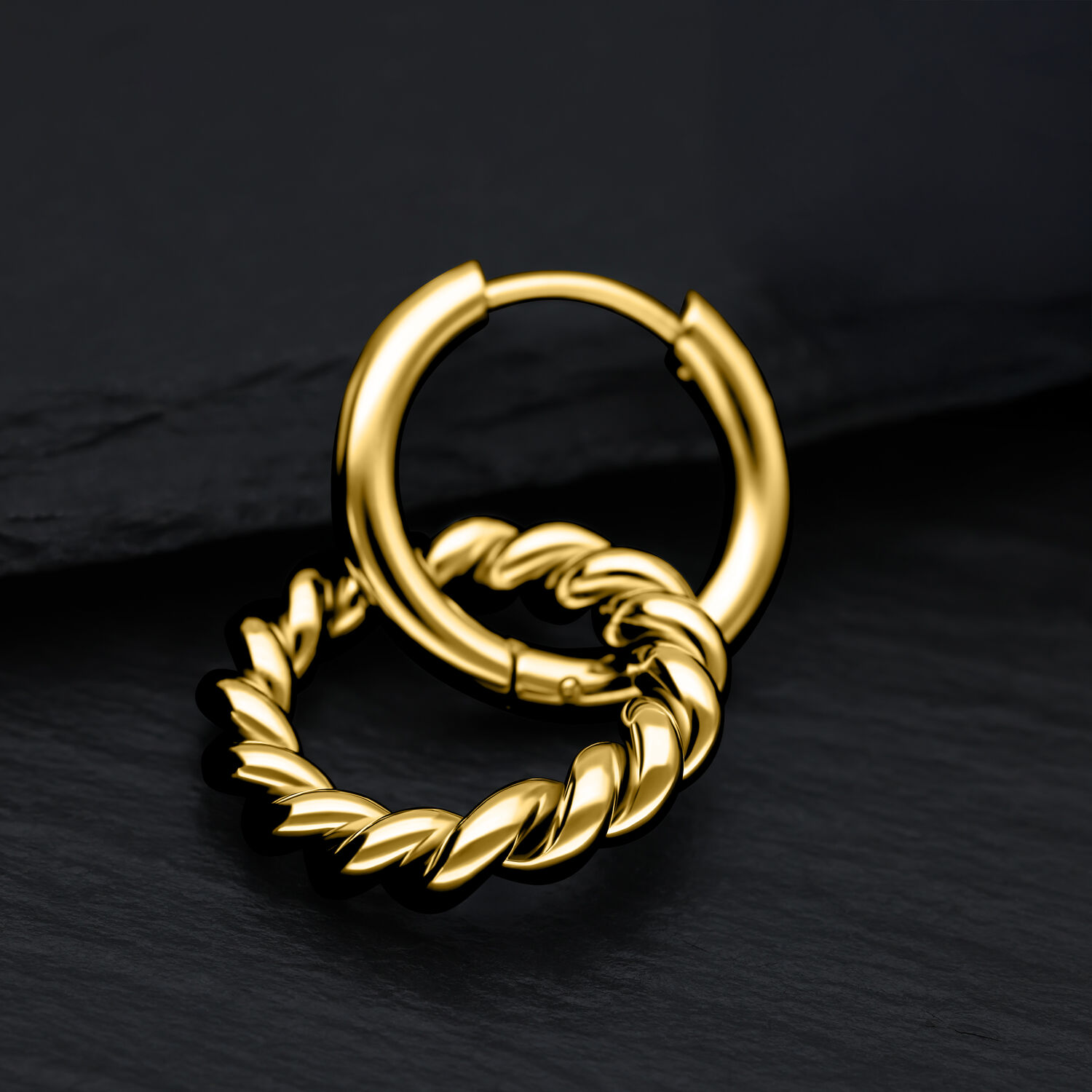 Dos aros dorados con diseño retorcido sobre fondo negro