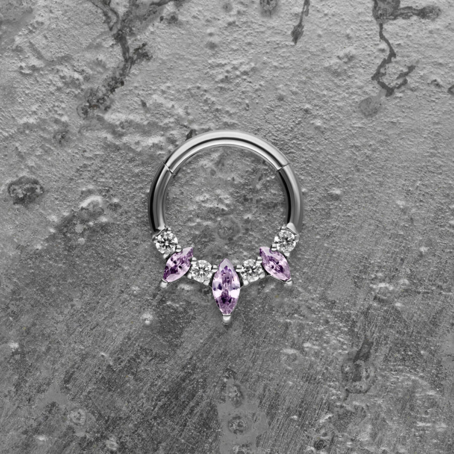 Clicker de septum plateado con cristales lavanda sobre fondo gris