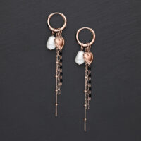 Roségoldene Ohrringe mit Herz und Perlen auf grauem Hintergrund