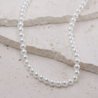 Collar grande de perlas sintéticas sobre fondo claro