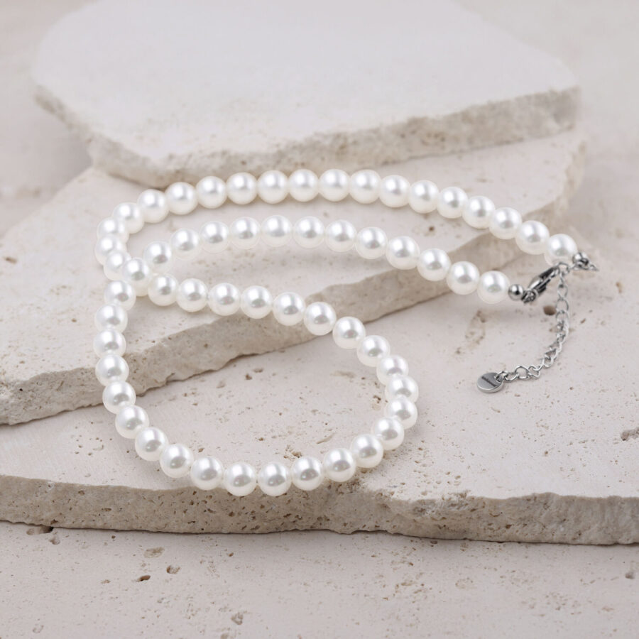 Collar de perlas blancas sintéticas sobre fondo claro
