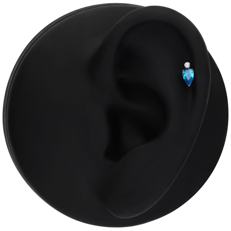 Adorno Push Fit plateado con cristal turquesa sobre fondo negro