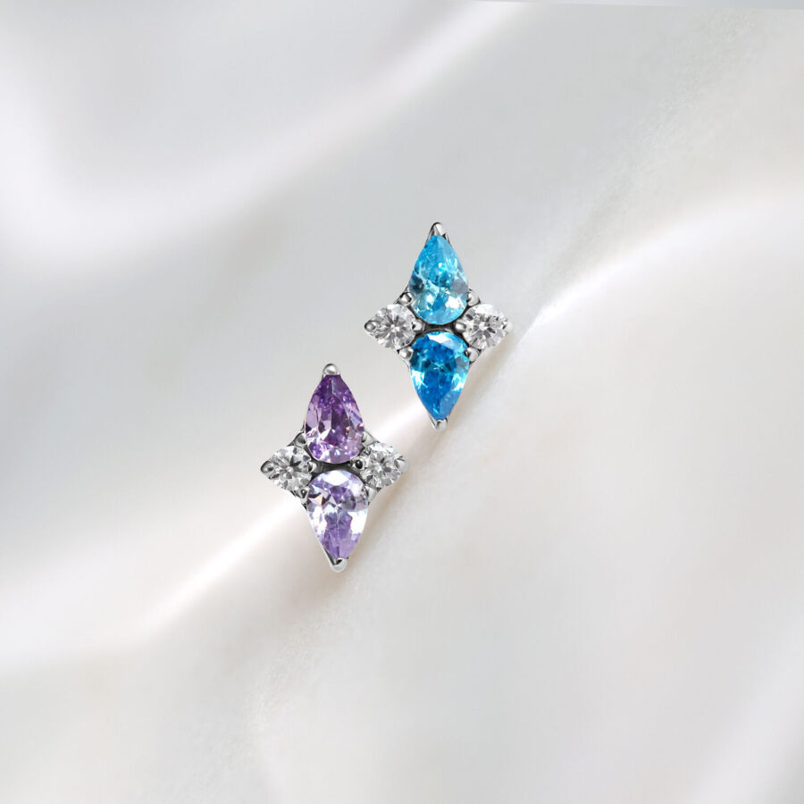 Dos accesorios Push Fit de titanio en lavanda y turquesa sobre fondo blanco
