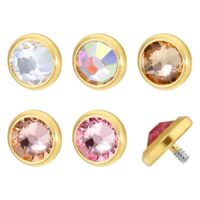 Fünf goldene Titan Piercing-Aufsätze mit klaren und bunten Kristallen auf weißem Hintergrund