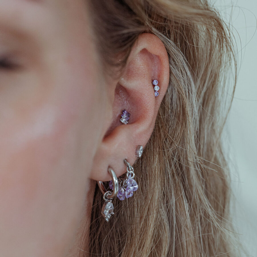 Cristal lavanda en metal plateado en la oreja, primer plano