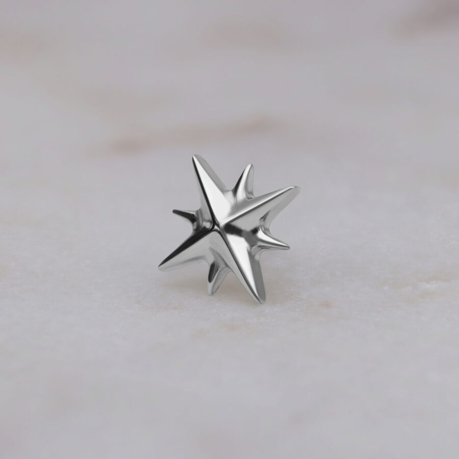 Ajuste en forma de estrella de titanio plateado sobre fondo claro