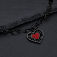 Schwarzes Herzarmband aus Chirurgenstahl Schwarzes Armband mit rotem Herzanhänger auf dunklem Hintergrund