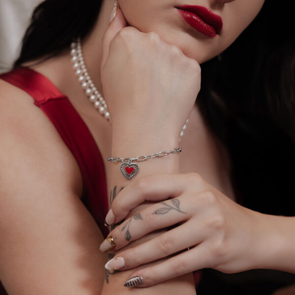 Mujer con pulsera Sacred Heart de acero quirúrgico plateado, diseño de corazón rojo