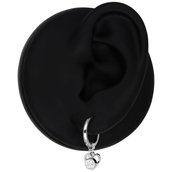 Pendientes plateados con colgante de corazón y cristal sobre fondo negro