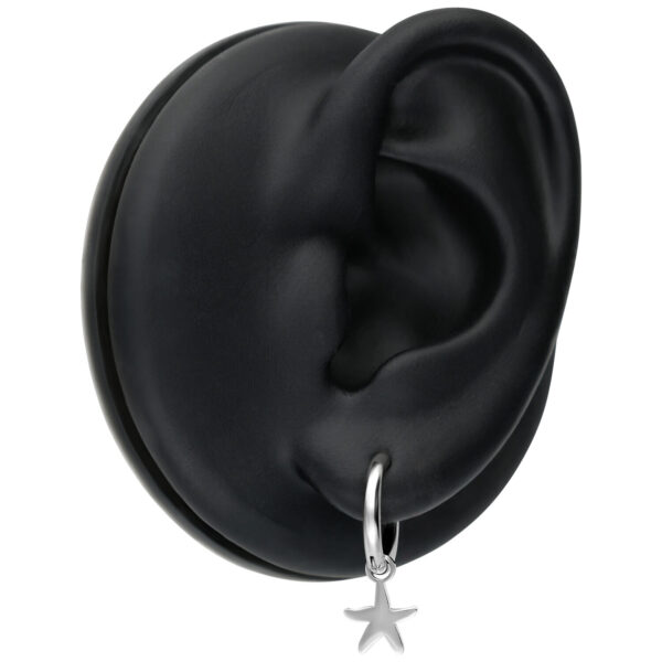 Pendientes mini de estrella de mar plateados en un maniquí de oreja negra