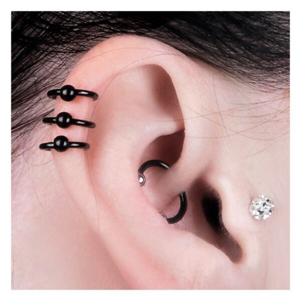 Oreja con pendientes negros de acero quirúrgico y pequeño cristal
