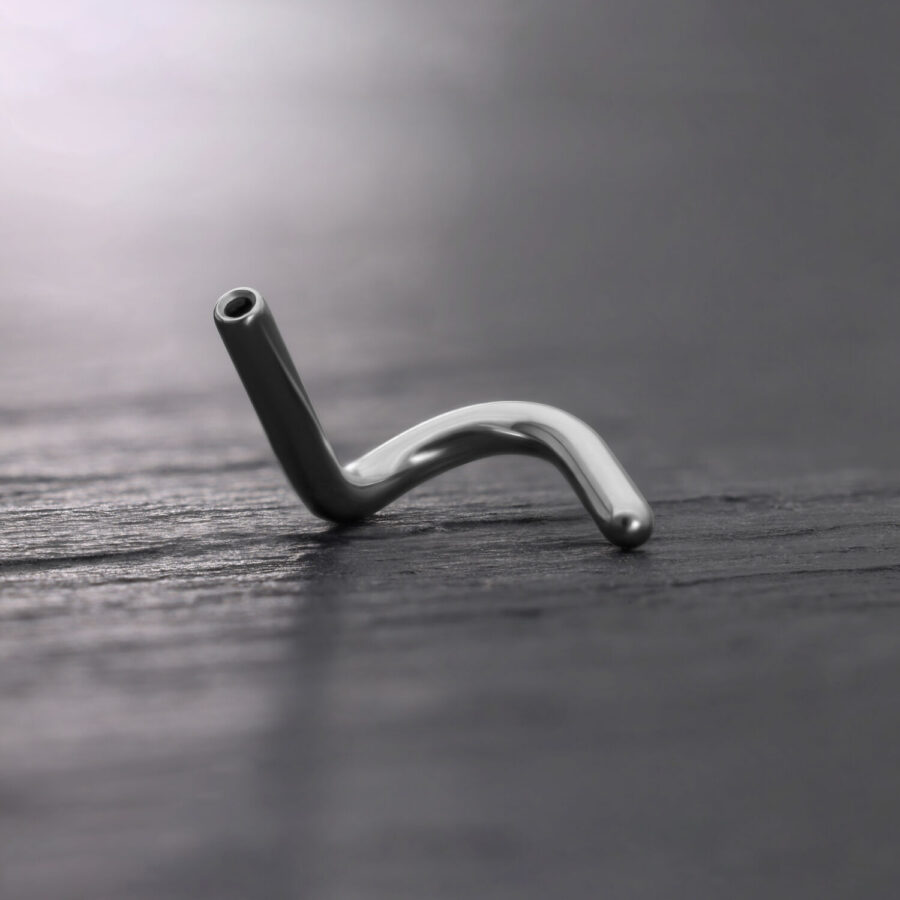 Piercing nasal de titanio plateado Push Fit sobre fondo oscuro