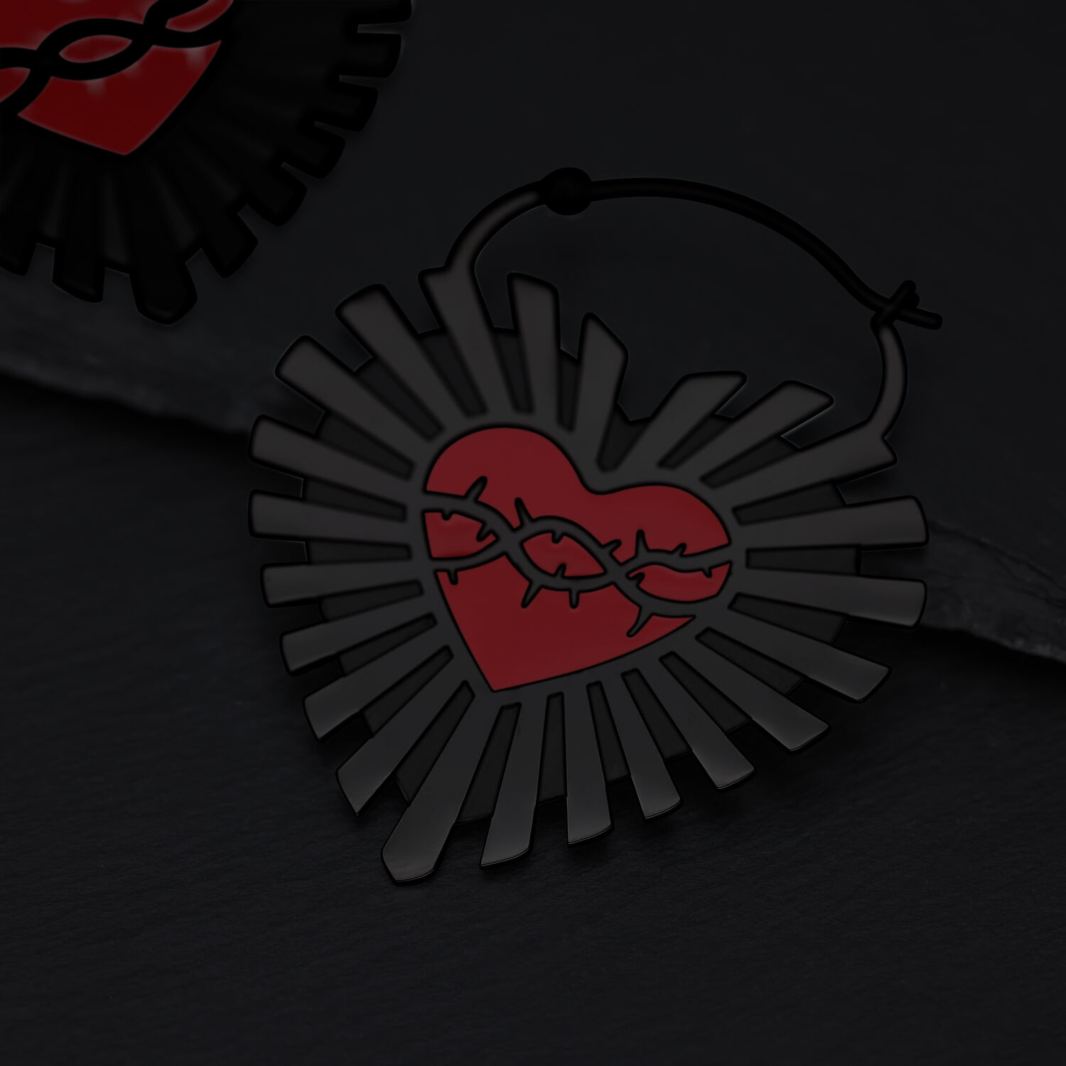 Schwarze Sacred Heart Creolen aus Chirurgenstahl Schwarze Ohrringe in Herzform mit Stacheldraht-Design auf dunklem Hintergrund