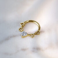 Clicker de Septum de Corazones de Cristal Dorado Clicker de septum dorado con diseño de corazón y cristal sobre fondo claro