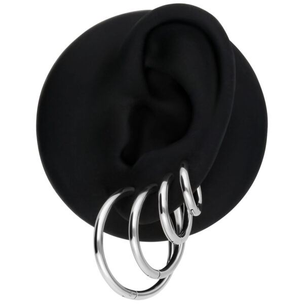 Juego de tres aros plateados en un modelo de oreja negra
