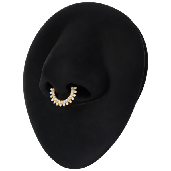 Aro de septum dorado con Moissanita y diseño de rayos de sol sobre fondo negro