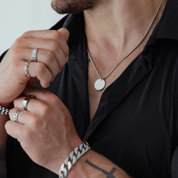 Cadena unisex de acero quirúrgico, llevada por una persona con camisa negra